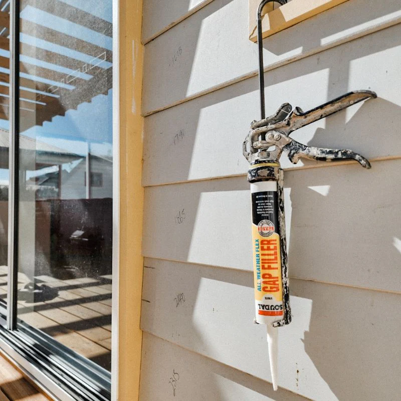 Soudal All Weather Flex sealant in a caulking gun applied to exterior weatherboard joints