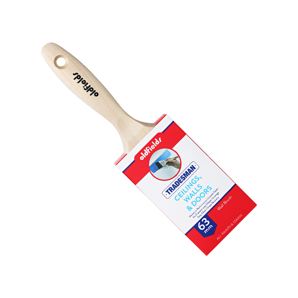 Angled view of Oldfields Tradesman 63mm paint brush with raw birch wood handle and grip