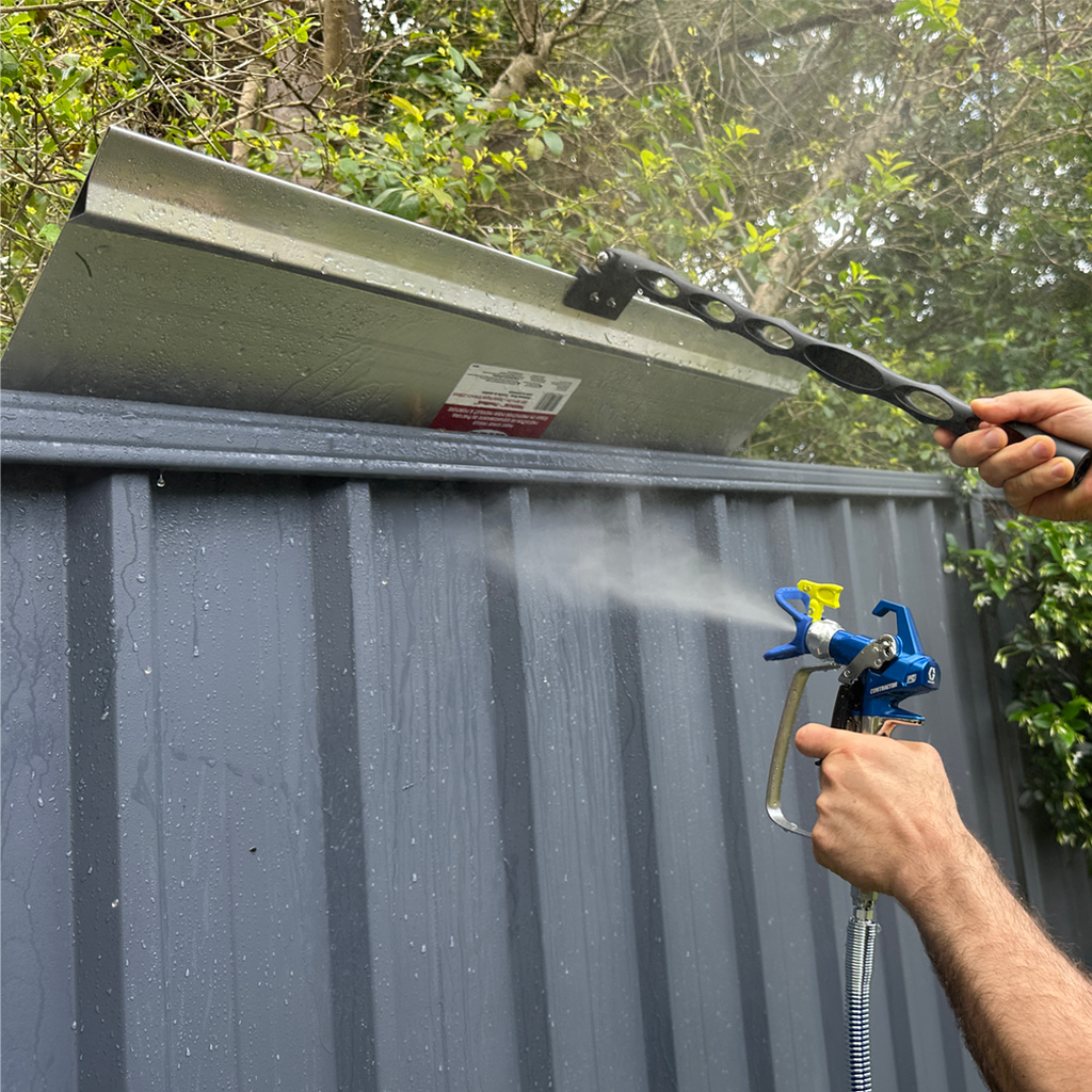 Professional painter using a 915mm iQuip shield for precise cut-ins during exterior spraying