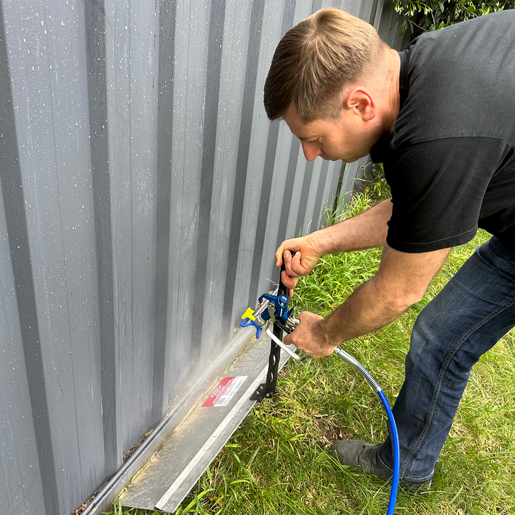 Using an iQuip spray shield at ground level to maintain a clean finish on a metal Colorbond fence