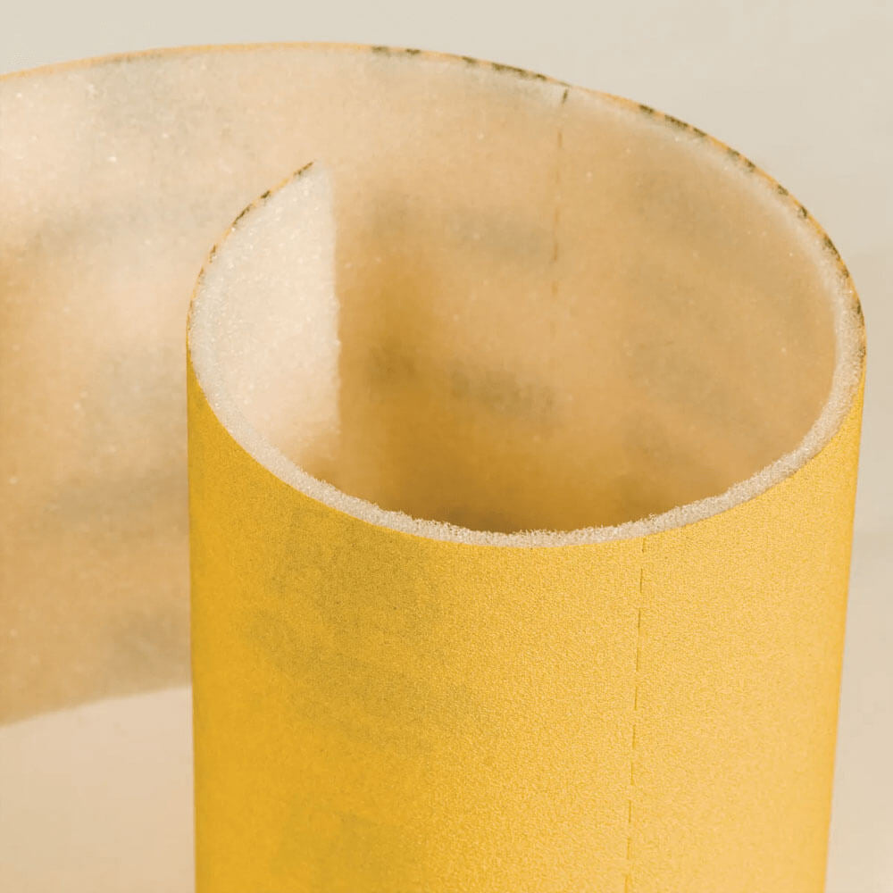 Close-up of the flexible PE foam backing on a gold aluminium oxide sanding sheet