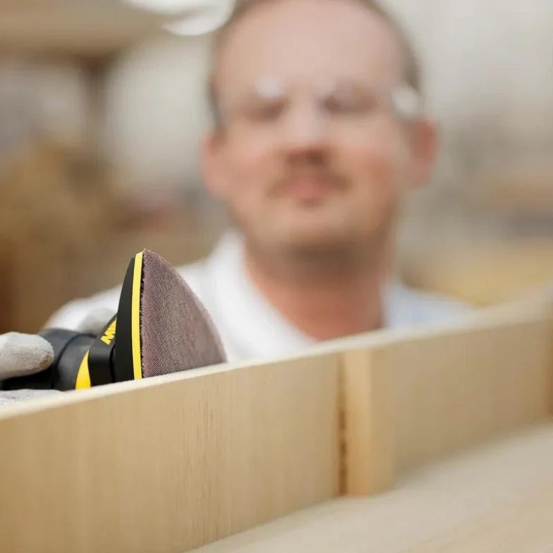 Professional woodworker finishing a timber surface with Mirka Abranet delta mesh abrasive
