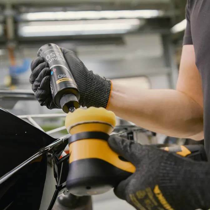 Applying Mirka PRO Iridium 1250 silicone-free compound to a yellow foam pad for a high-gloss finish