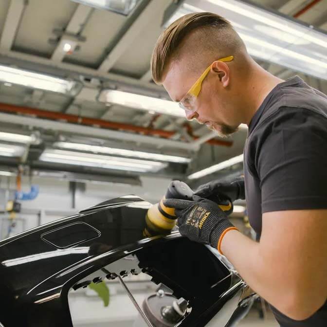 Professional detailer wearing safety glasses using Mirka PRO Finishing Solution for a swirl-free shine