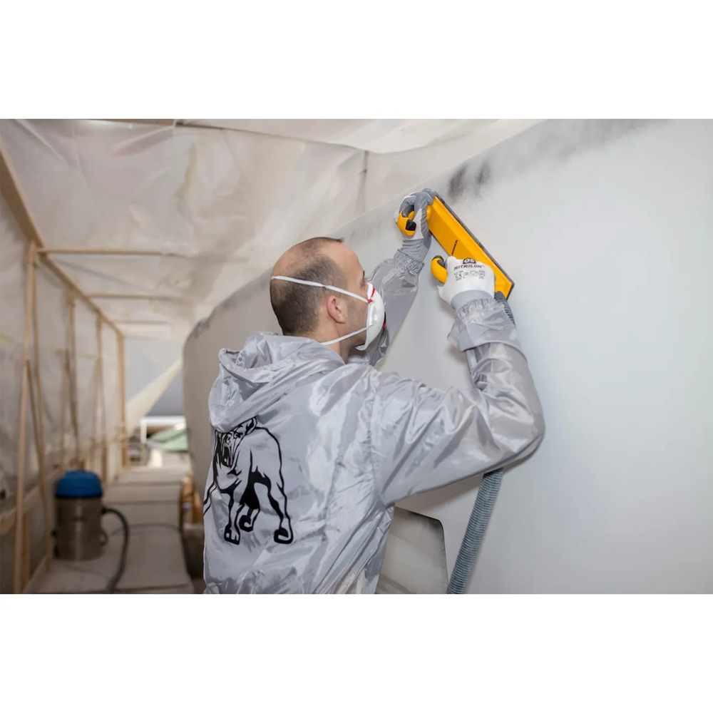 Professional sanding a large marine hull panel with a Mirka rigid file board