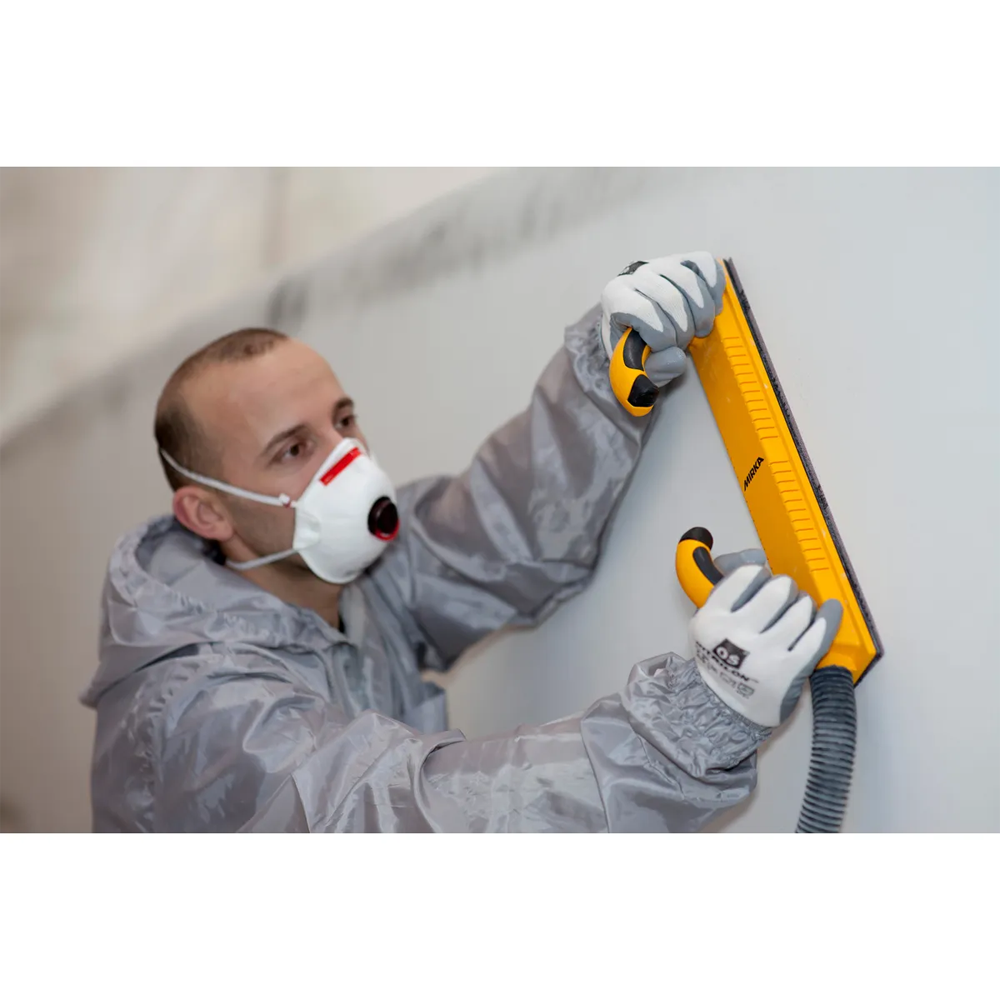 Close-up of a tradie using a rigid 70x400mm Mirka board connected to a dust extractor