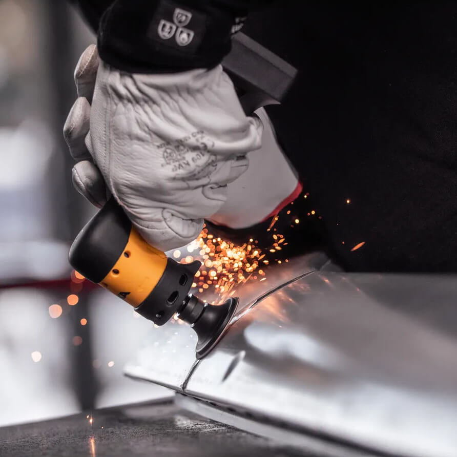Close-up of a professional grinding metal welds with sparks using the Mirka ANGOS