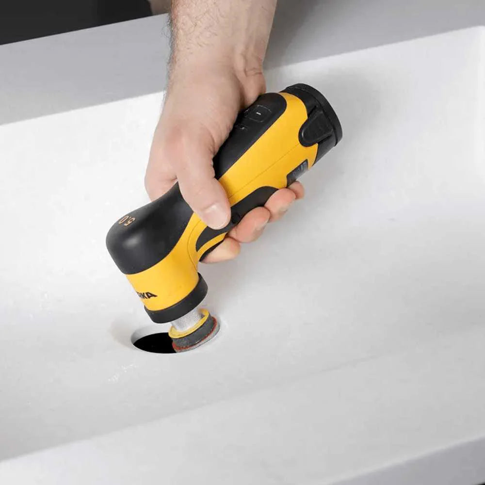 Handheld Mirka AROS-B sander being used for precision surface finishing on a solid surface