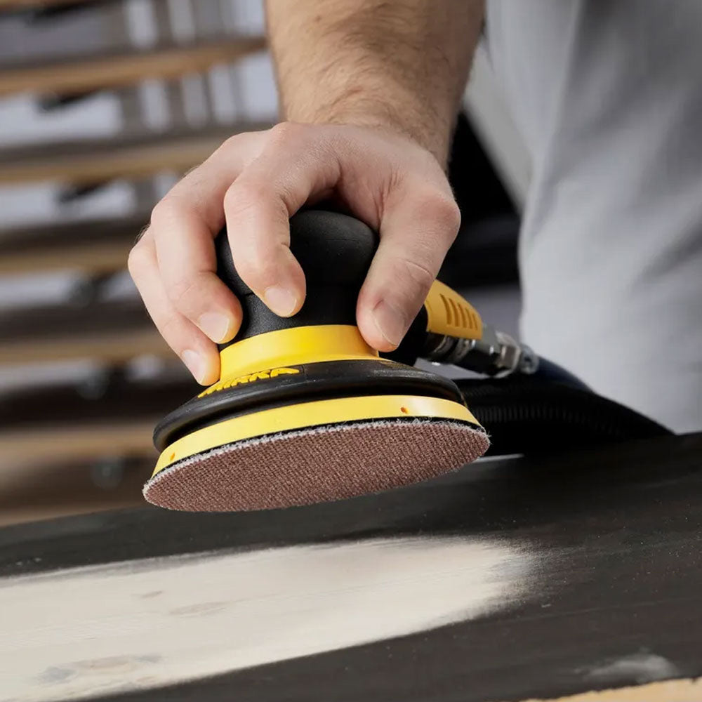 Tradie using a Mirka PROS 650CV pneumatic sander on a timber surface for a high-quality finish