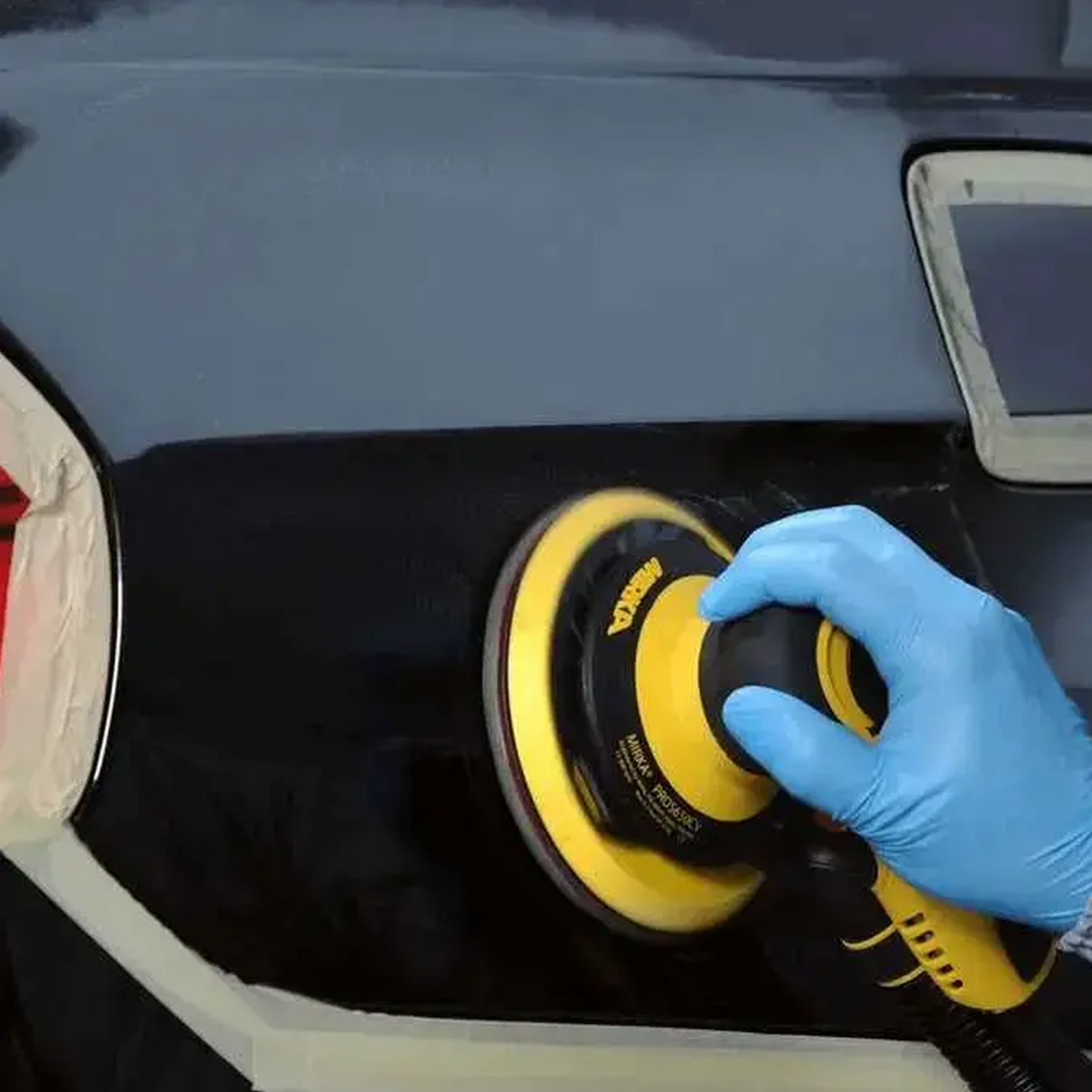 Professional using a 150mm Abralon foam disc on a car panel for lacquer refinement