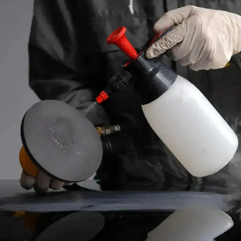 Tradie using a spray bottle for wet sanding with a multifunctional Abralon finishing disc