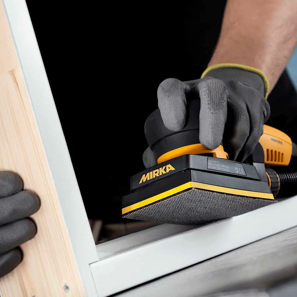 Professional sanding a white timber window frame with an Abranet Ace ceramic sheet