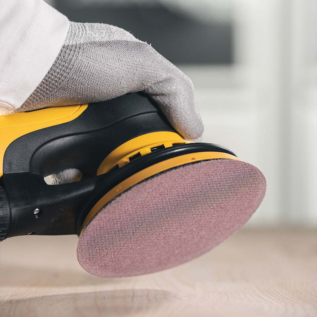 Professional tradie using a Mirka sander with a 150mm Abranet Ace disc on wood