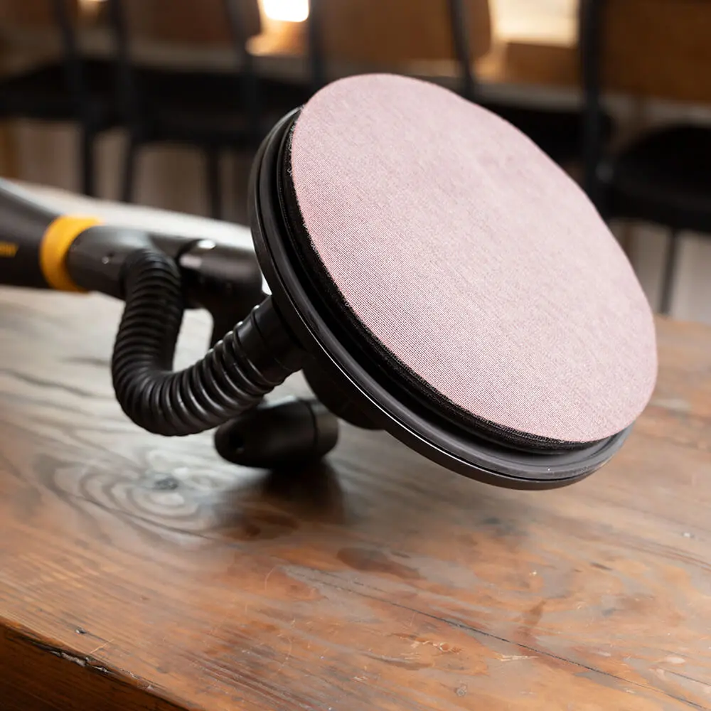 Professional using a 225mm Abranet mesh disc on a long-handle wall sander for timber prep