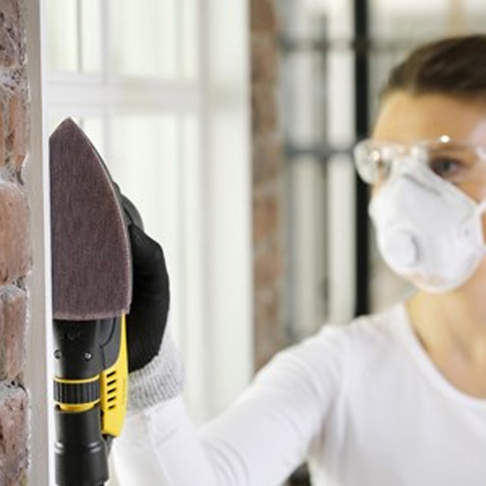 Sanding a white window frame with a Mirka Delta interface pad for a smooth finish