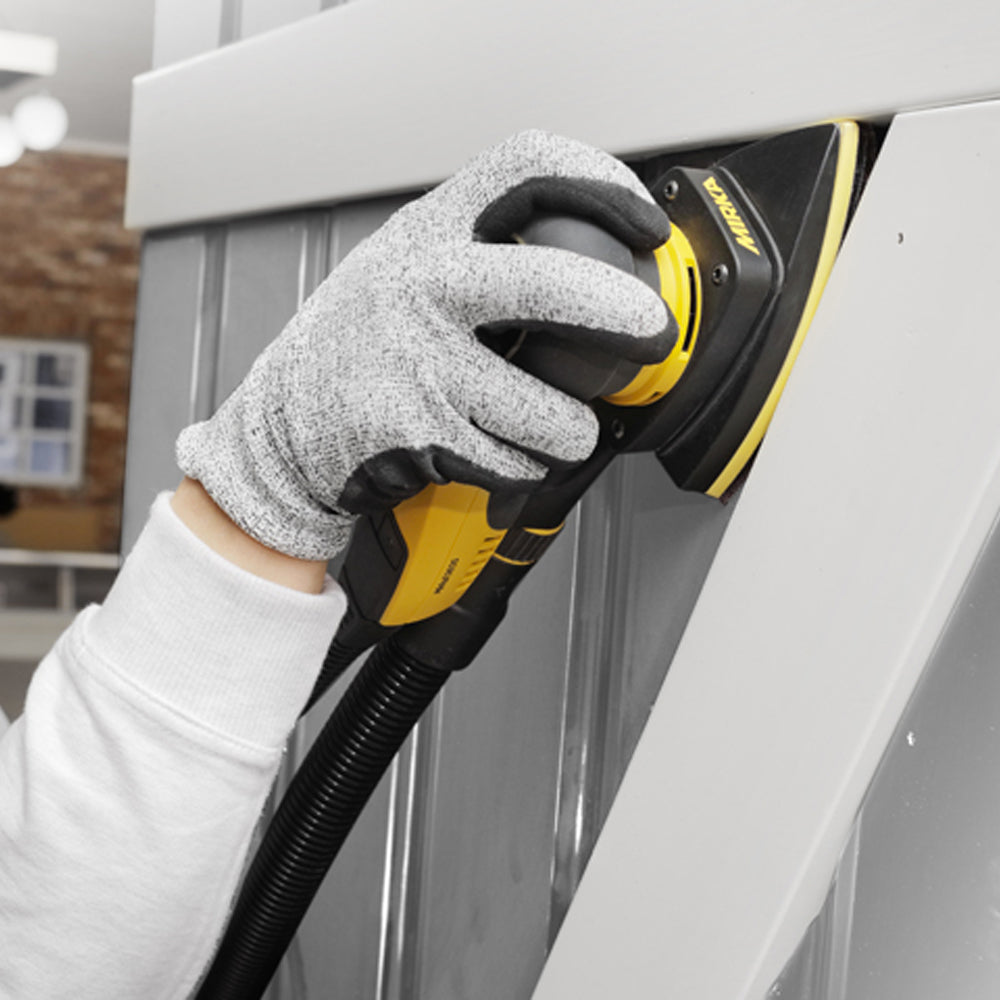 Tradie using a Mirka DEOS Delta sander with an interface pad on a grey panel