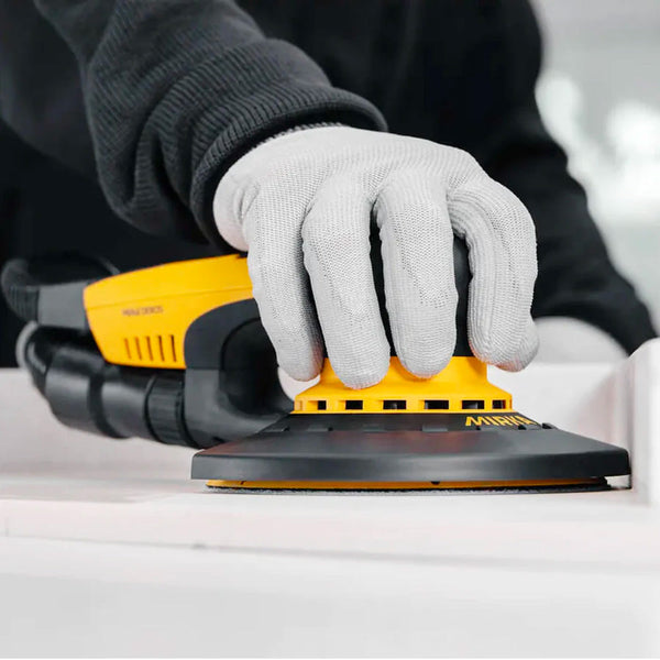Professional tradie using a Mirka DEROS with an edge protector to sand close to a wall