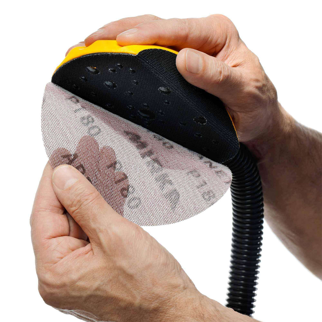 Tradie attaching a Mirka Abranet mesh disc to the ergonomic Roundy hand sanding block