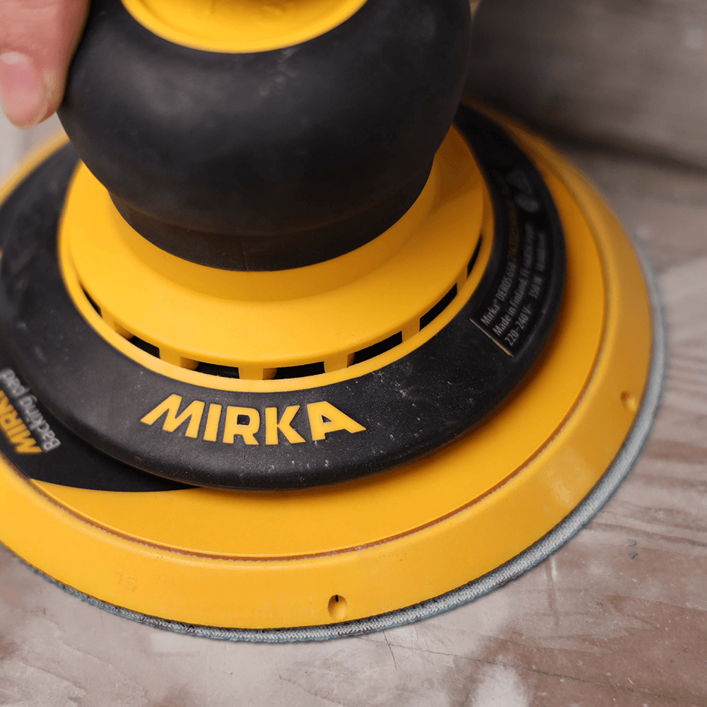 Close-up of Mirka DEROS dust extraction port connected for a dust-free workspace