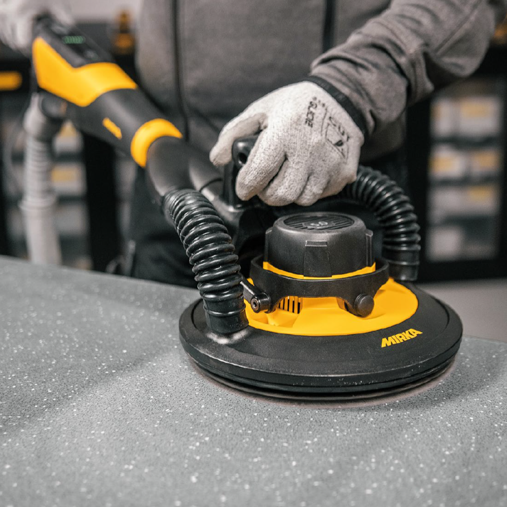 Professional tradie using the LEROS-S sander on a benchtop with dust extraction