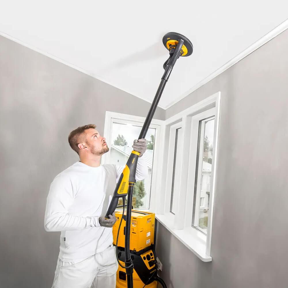 Tradie finishing high plasterboard corners using the flexible Mirka LEROS long-reach sander