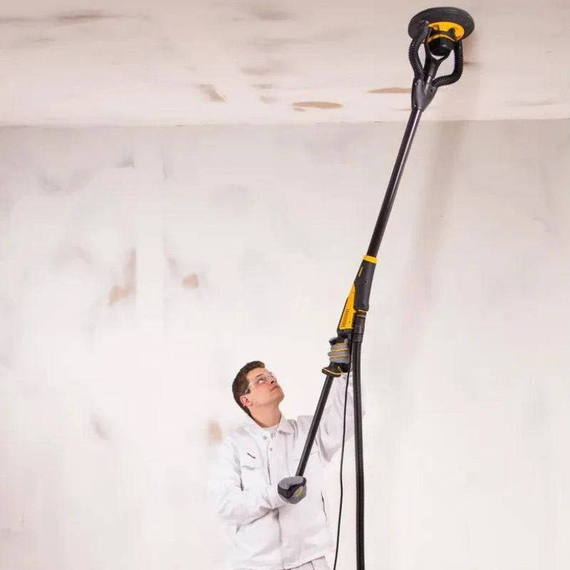 Professional tradie sanding a high plasterboard ceiling using the Mirka LEROS extension